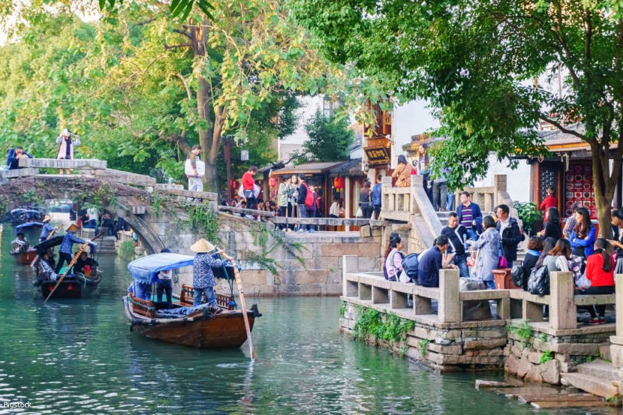 Suzhou, China - Nov 5, 2016: Boats with tourists cruised by at the historic Zhouzhuang Water Town.