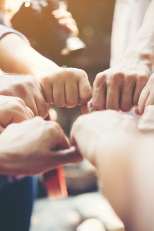 Close up of young people putting their hands together. Team with stack of hands showing unity and teamwork.